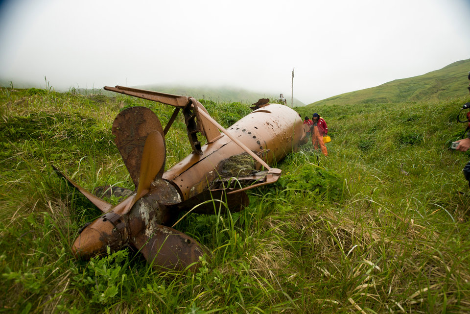 Members of the expedition take time to examine a Japanese mini submarine that remains in the historic sub pens on Kiska Island. Image courtesy of Kiska: Alaska's Underwater Battlefield expedition.