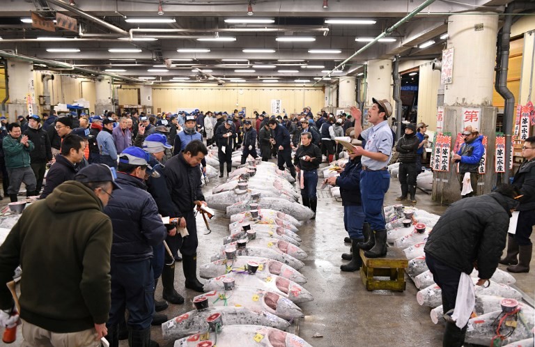 An auctioneer starts its new year auction of the frozen tuna at the Tsukiji fish market in Tokyo on January 5, 2018. The famous market opened its doors for public viewing of their tuna auction one last time on Friday before moving to the new location in Toyosu. (AFP/Kazuhiro Nogi)