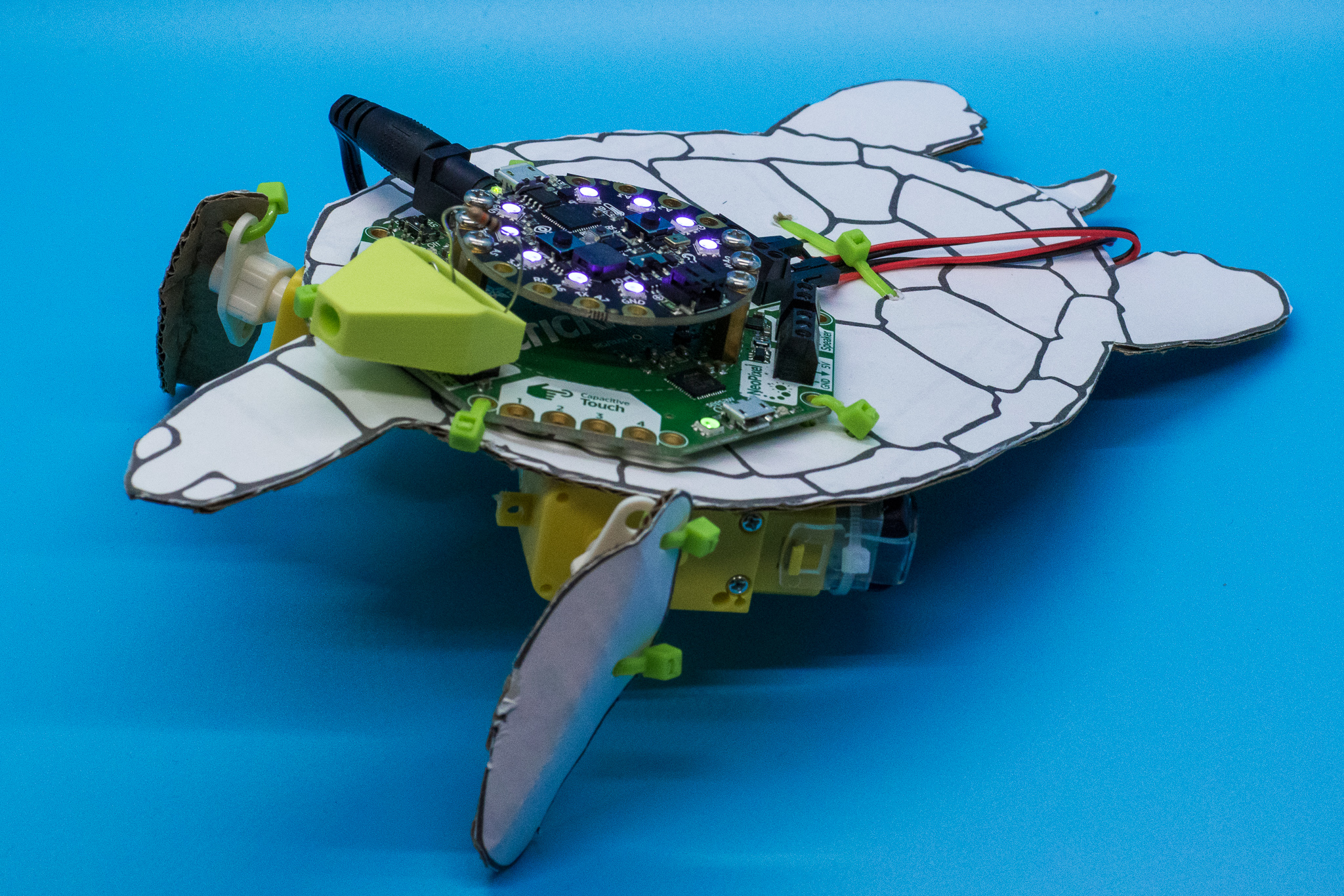 A sea turtle robot looking fearsome on a blue background.